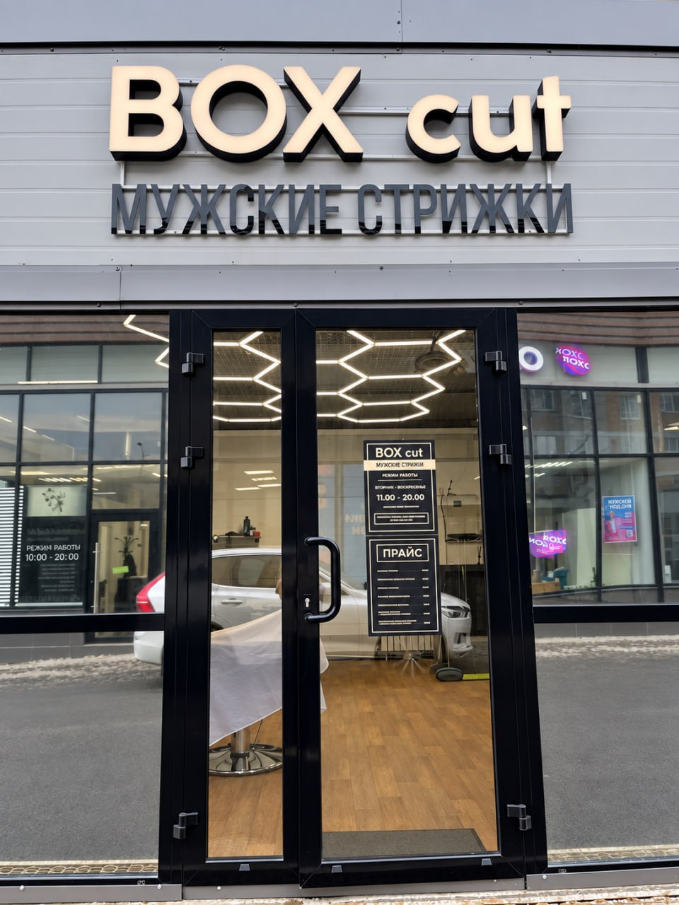 Вход в барбершоп BOX cut с подсвеченной вывеской